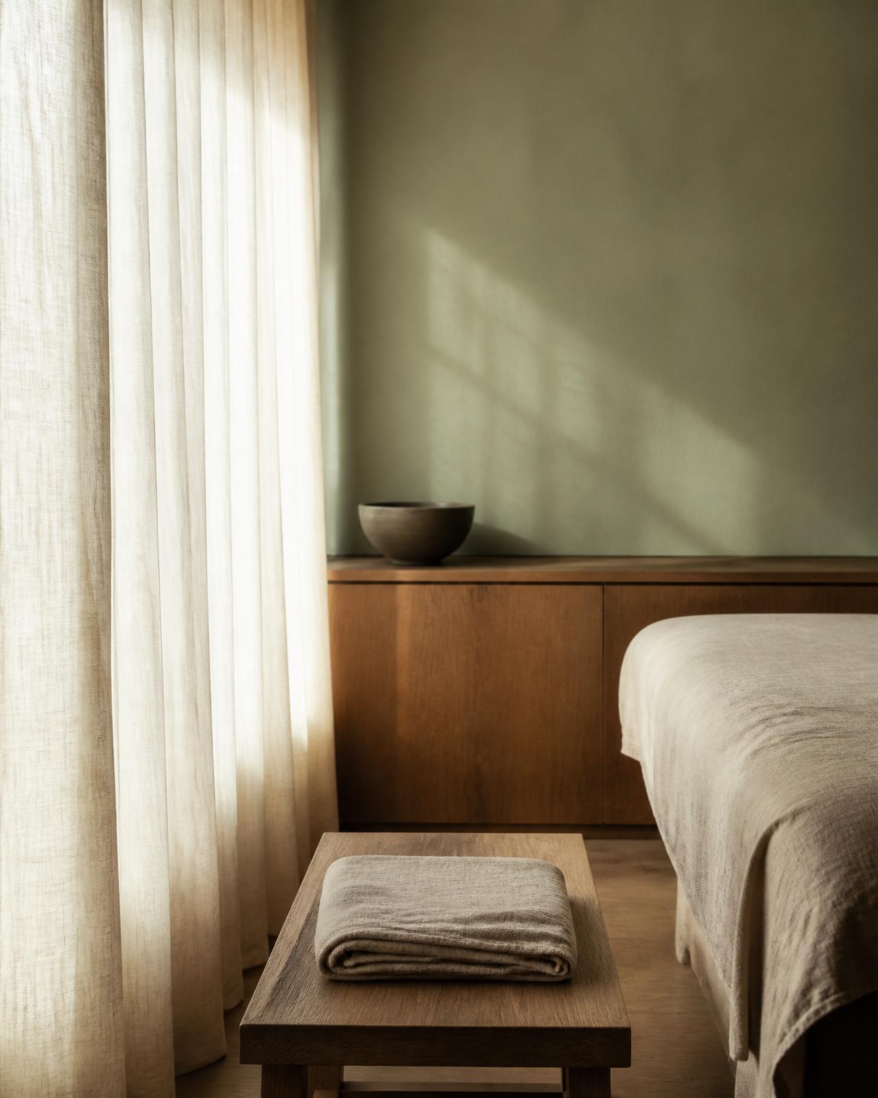 Atelier Hagens behandlingsrum med naturligt ljus, linnetextilier och salviegröna väggar